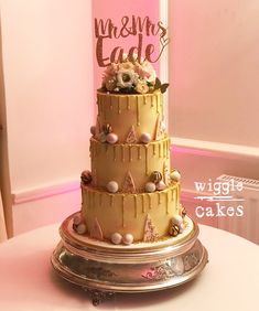 a tier pink and gold chocolate drip cake with pink shards oreo cake pops