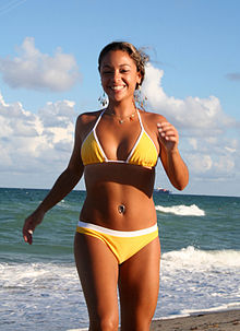 a woman wearing a bikini at a beach