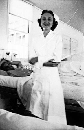 army nurse rachel brower twiddy stands at the bedside of a patient while at work
