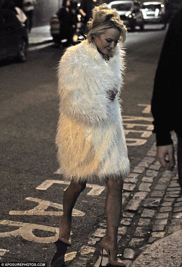 chic the former baywatch star initially covered her modesty in an opulent white fur coat