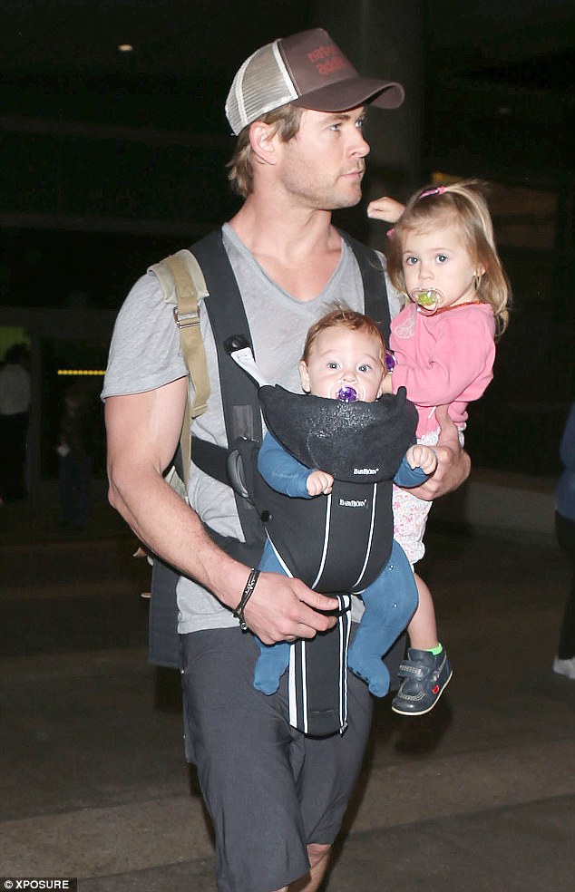 daddy cool chris hemsworth arrives at los angeles international airport with some very important luggage