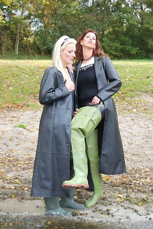 girls wearing hip waders and rubber raincoats in the mud waders
