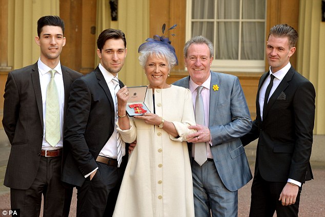lynda received her obe with left to right sons robbie and michael husband