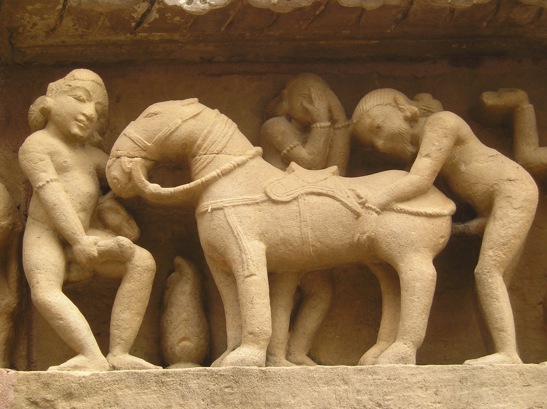 man having intercourse with a horse pictured on the exterior of a temple in khajuraho
