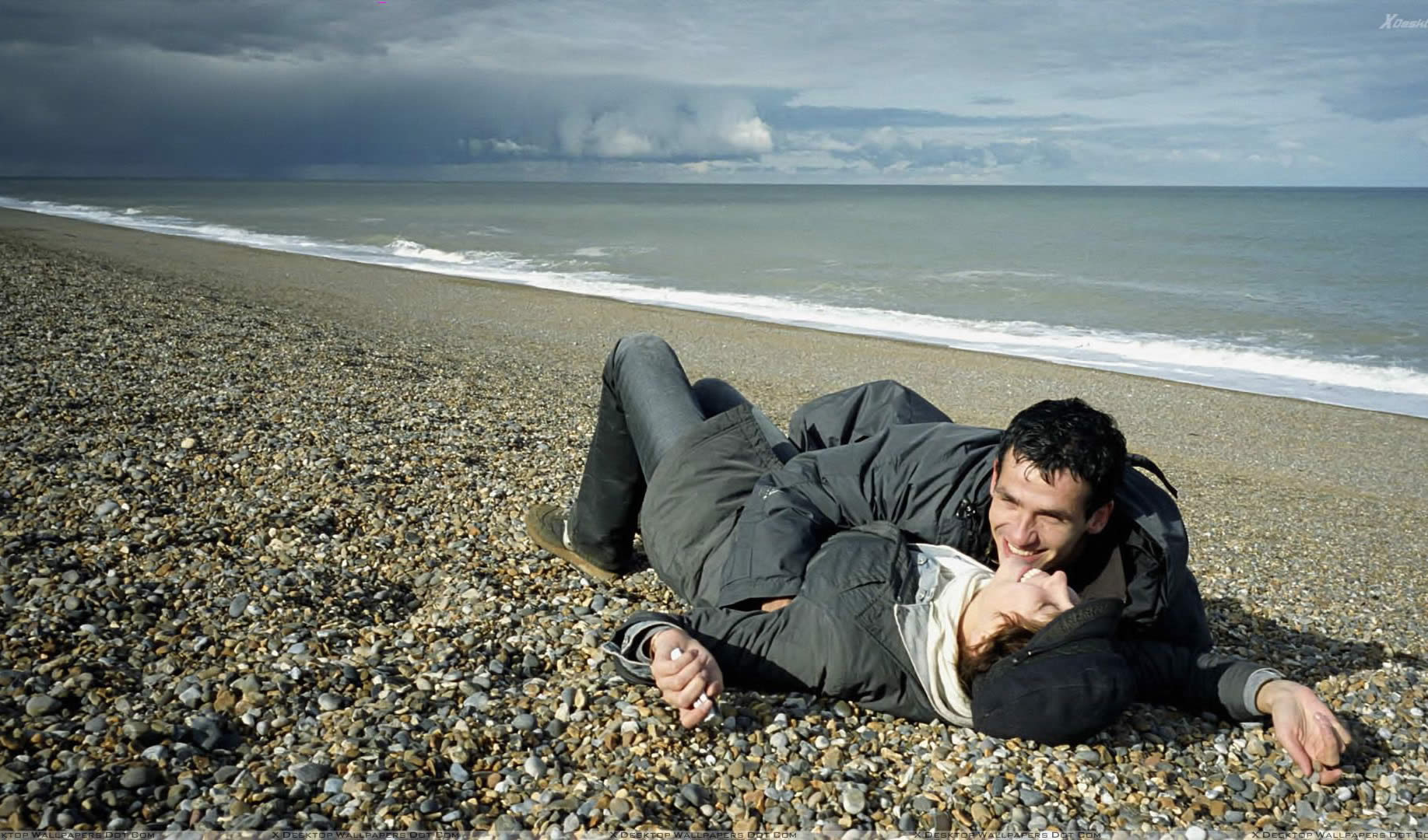 movie couple on the beach lying down and hugging in songs