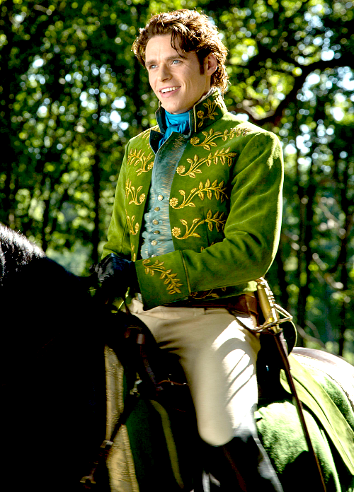 prince charming in a green brocade jacket a blue cravat and some white pants that