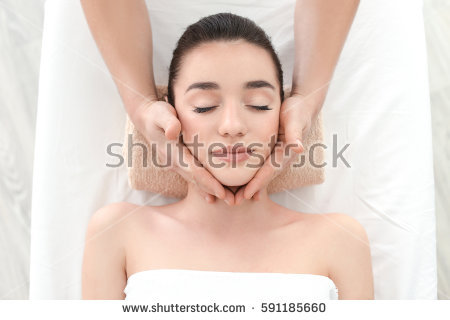 stock photo beautiful young woman receiving facial massage in spa salon