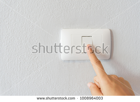 stock photo close up of woman finger turning on light switch with white background copy space