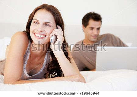 stock photo couple in bedroom man using laptop woman using telephone