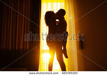 stock photo interracial couple being intimate in front of window passionate couple kissing boy and girl 1
