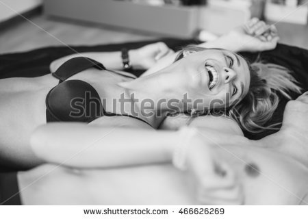 stock photo overhead close up portrait of a young romantic couple hugging and kissing laying down on a white