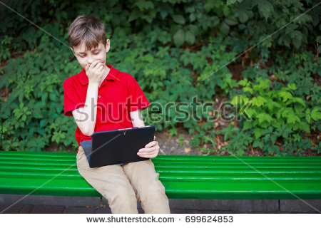 stock photo parental advisory stunned boy sitting with tablet in hands education childhood family