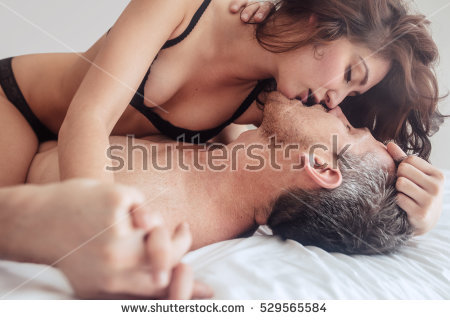 stock photo young couple being intimate kissing on bed sensual lovers making love in bedroom