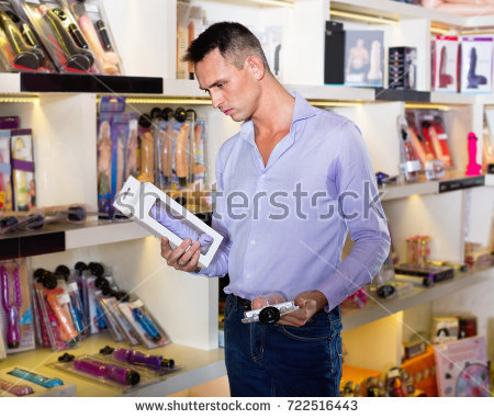 stock photo young positive glad male client shopping sex toy in store for adults