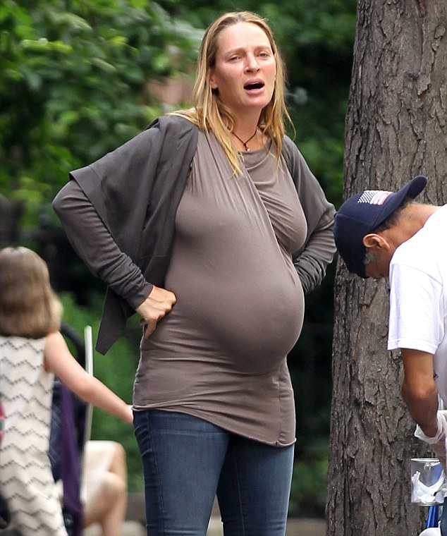 uma thurman shows off growing baby bump poking through her clingy