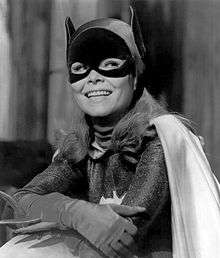 yvonne craig poses in the batgirl costume from the television show holding the cape open